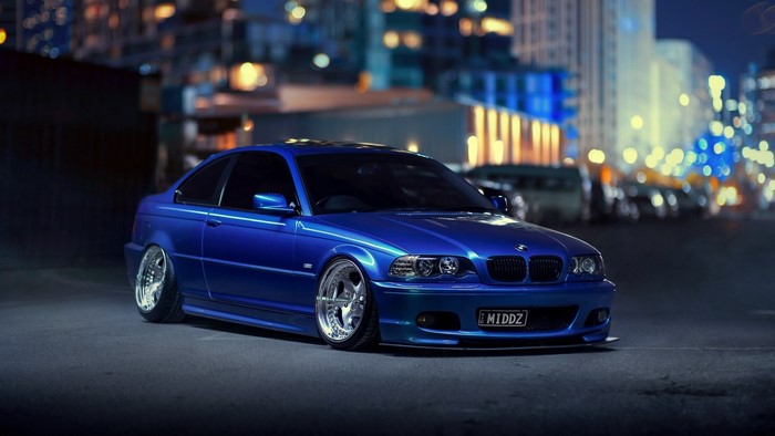 Blue BMW coupe with custom wheels at night