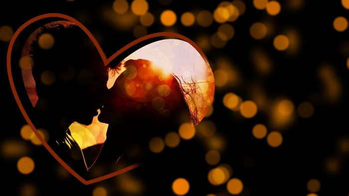 Silhouette of a couple kissing inside a heart