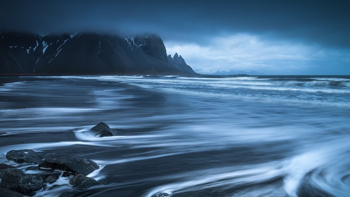 Dark moody seascape with mountains and waves