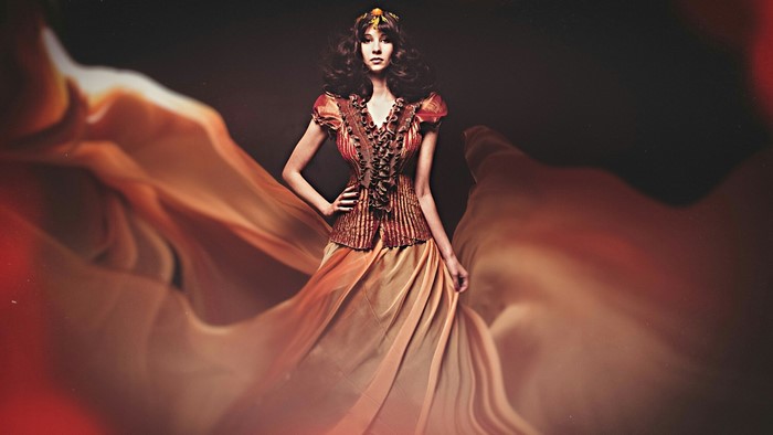 Woman in ornate dress with flowing fabric