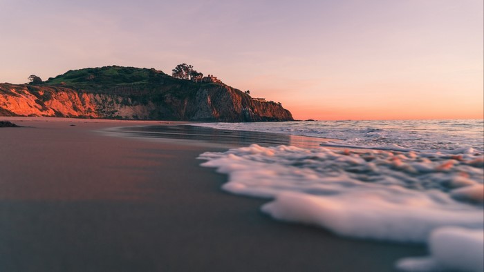 Beach cliff at sunset with ocean waves