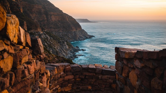 Rocky cliffside overlooking the ocean at sunset
