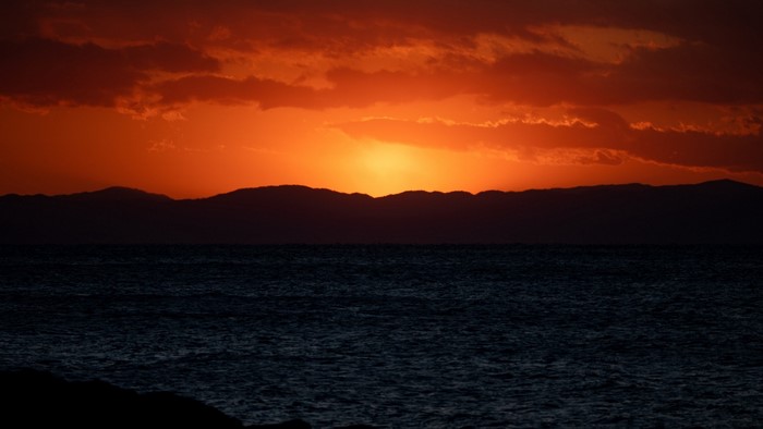 Sunset over the ocean with mountains