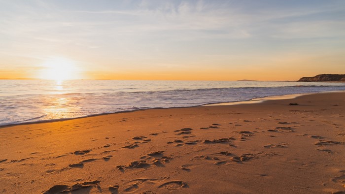 Beach at sunset with footprints