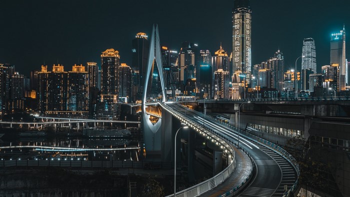 Night cityscape with illuminated bridge and skyscrapers
