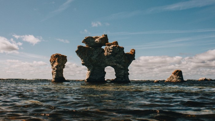 Sea stacks in the ocean under a cloudy sky