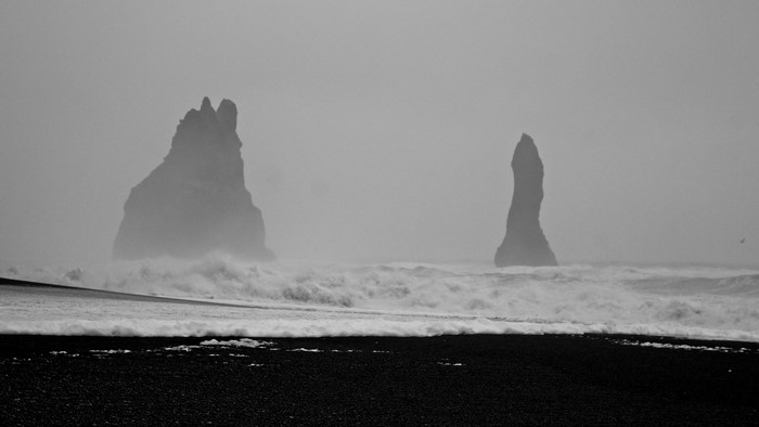 Black sand beach with sea stacks and waves