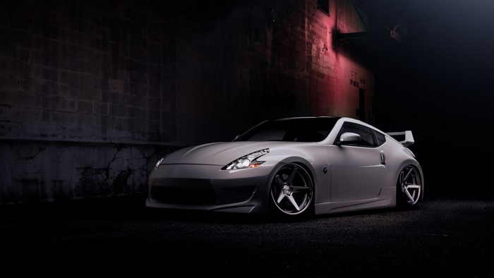 White Nissan 370Z Nismo parked near a brick wall