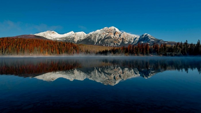 Mountain range reflected in a misty lake