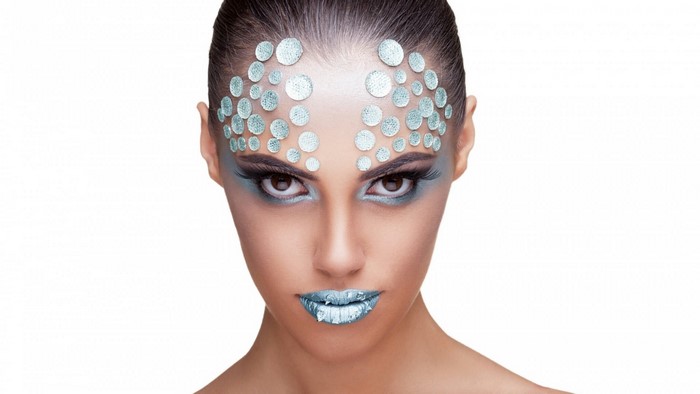 Woman with blue makeup and face gems