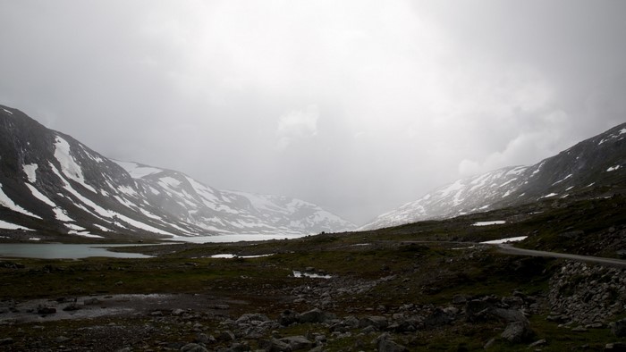 Misty mountain valley with snow and a lake