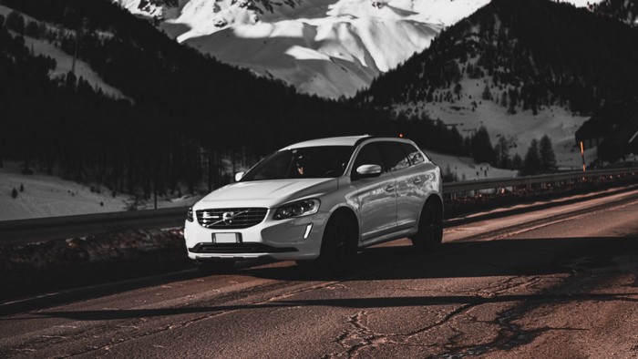 White Volvo XC60 driving on a mountain road