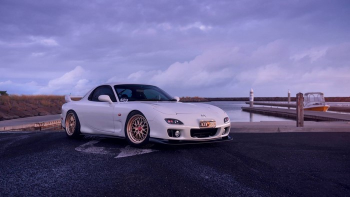 White Mazda RX-7 FD parked by a marina