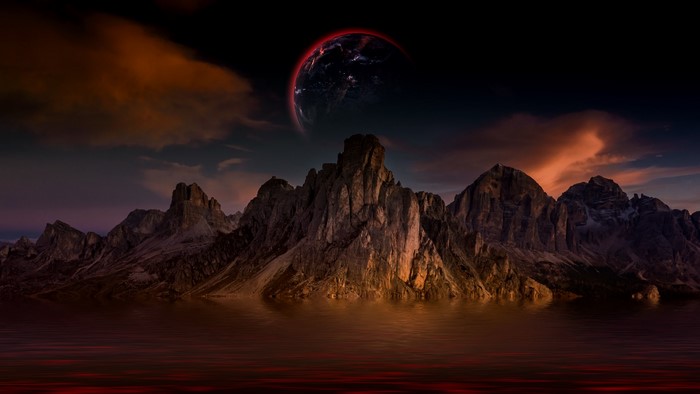 Planet over mountains reflected in water