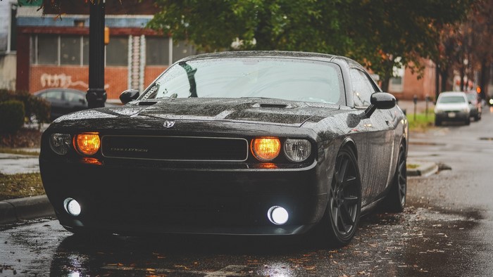 Black Dodge Challenger on a Wet Street