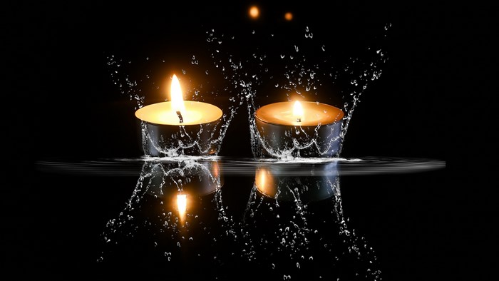Two lit candles with water splashes