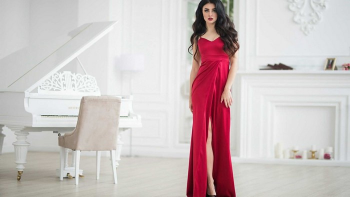 Woman in red dress by a white piano
