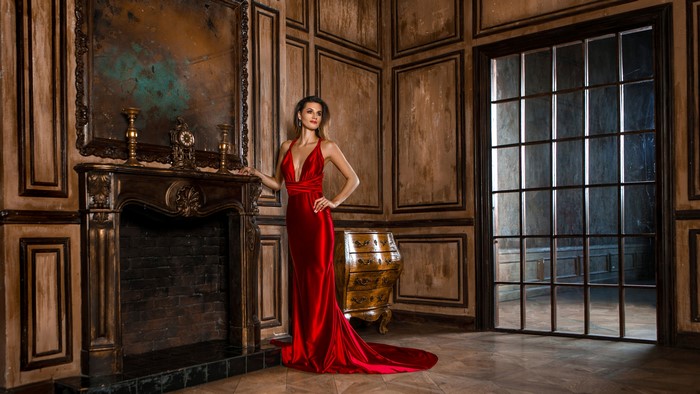 Woman in red dress by fireplace