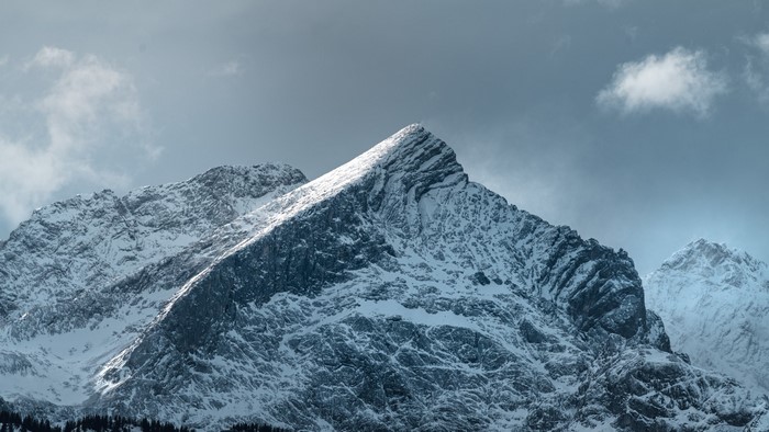 Snow-covered mountain peaks under a cloudy sky