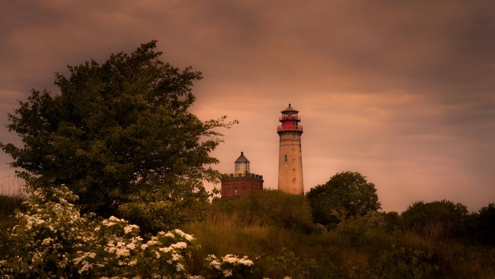 Two lighthouses on a hill with trees