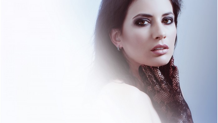 Woman with dark eye makeup and black gloves
