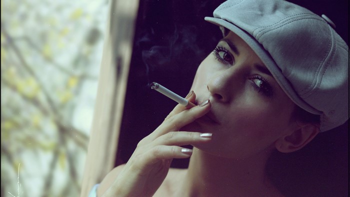 Woman in a cap smoking a cigarette