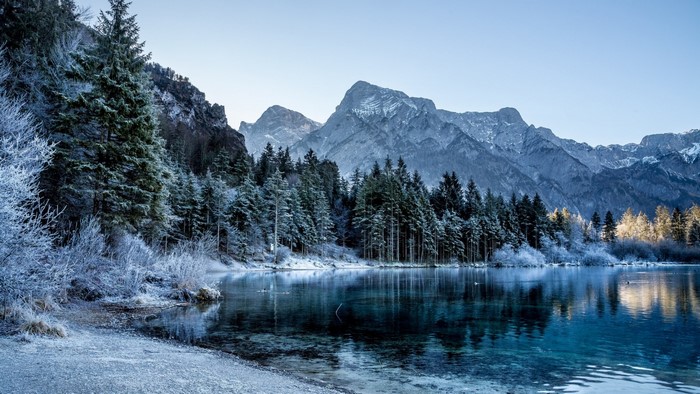 Winter forest and mountains reflected in a lake