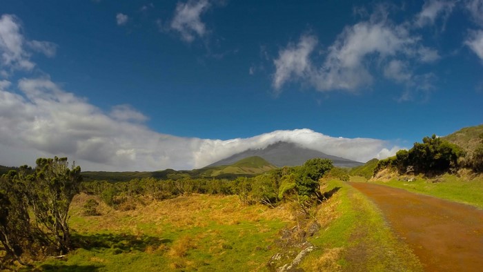 Mountain peak shrouded in clouds with a dirt road