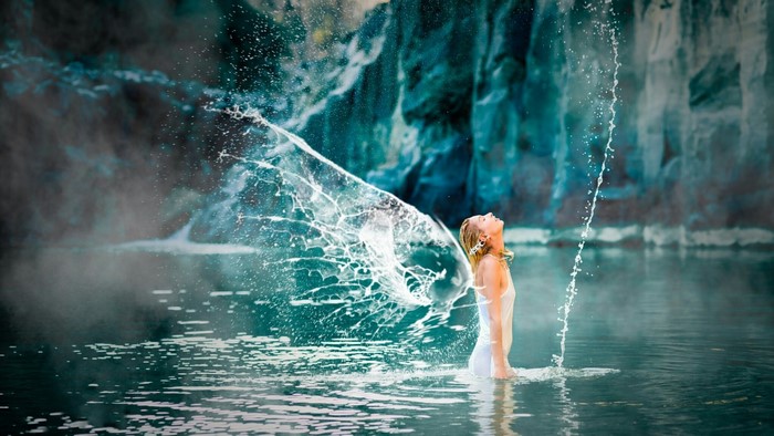 Girl splashing water in a rocky cove