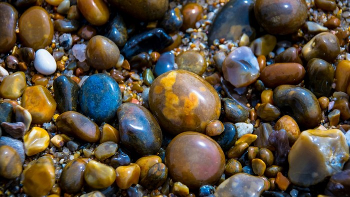 Close-up of wet, colorful pebbles on a beach