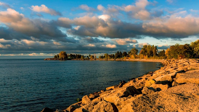 Rocky shoreline with calm sea and cloudy sky