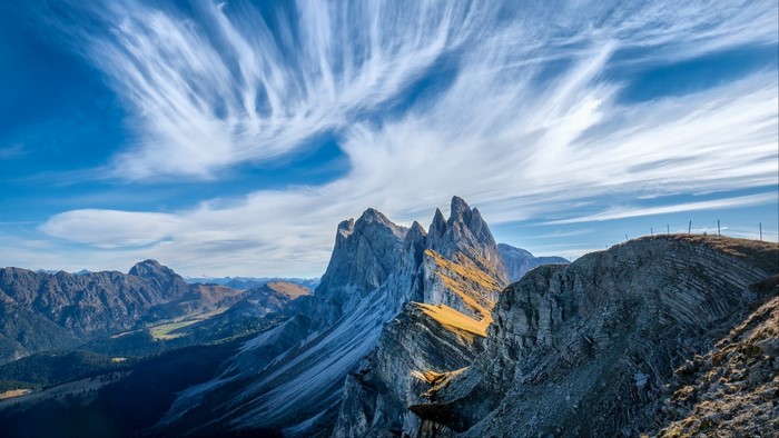 Dramatic mountain peaks under a wispy sky