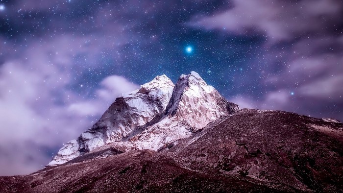 Snowy mountains under a starry night sky