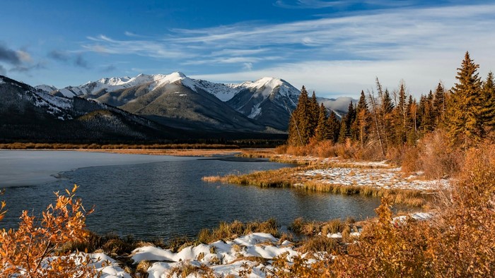 Autumn landscape with snow-capped mountains and lake