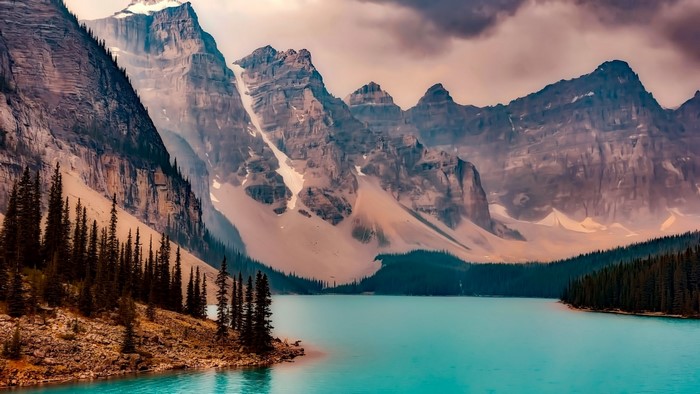 Turquoise lake and rocky mountains with pine trees