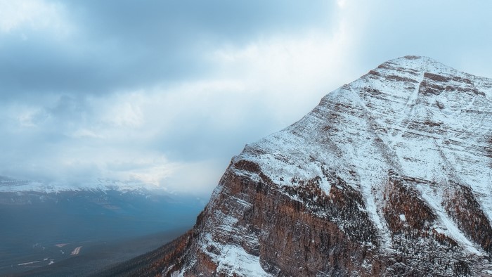Snow-covered mountain peak under cloudy sky