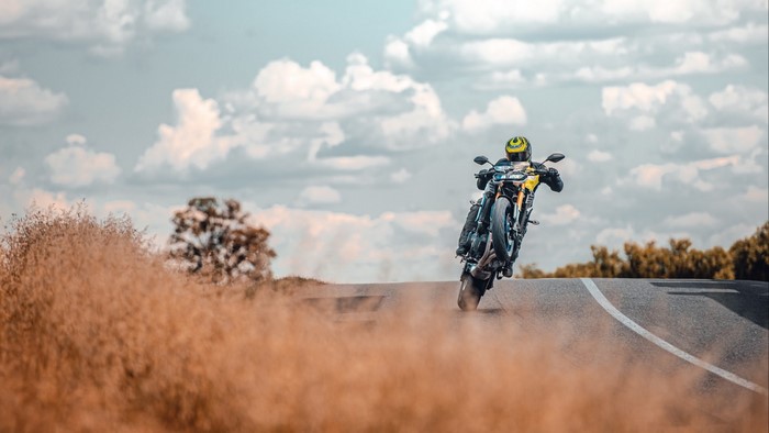 Motorcyclist performing a wheelie on a road