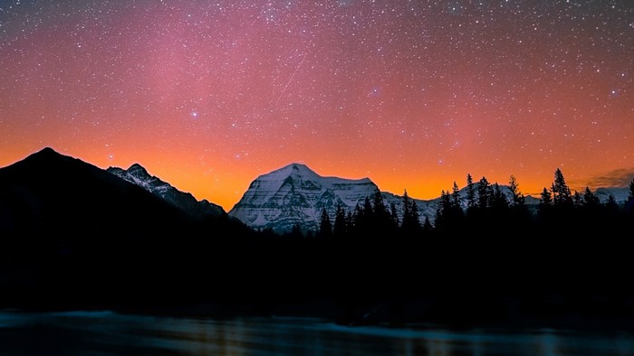 Mountain range under starry dusk sky