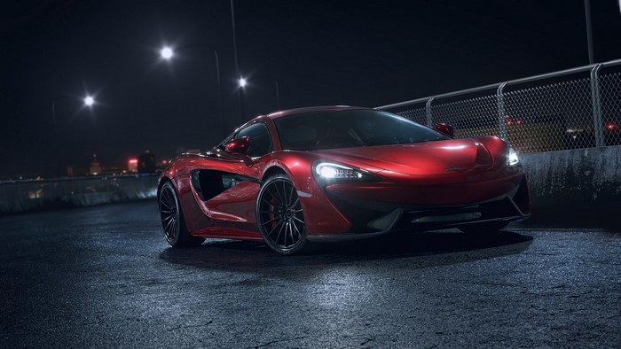 Red McLaren 570s on wet asphalt at night