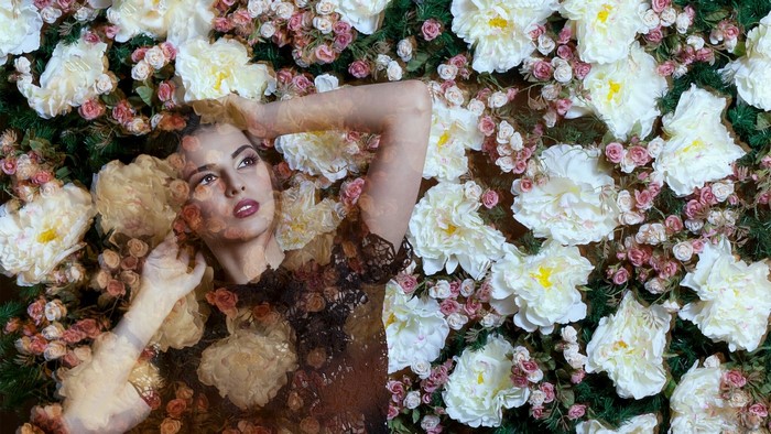 Woman lying in a bed of flowers