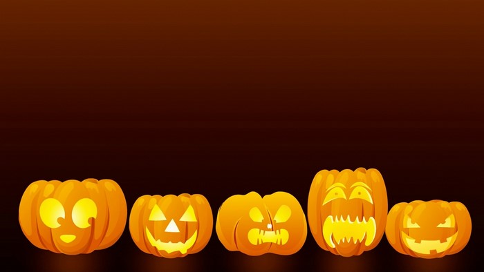 Five carved Halloween pumpkins with glowing faces