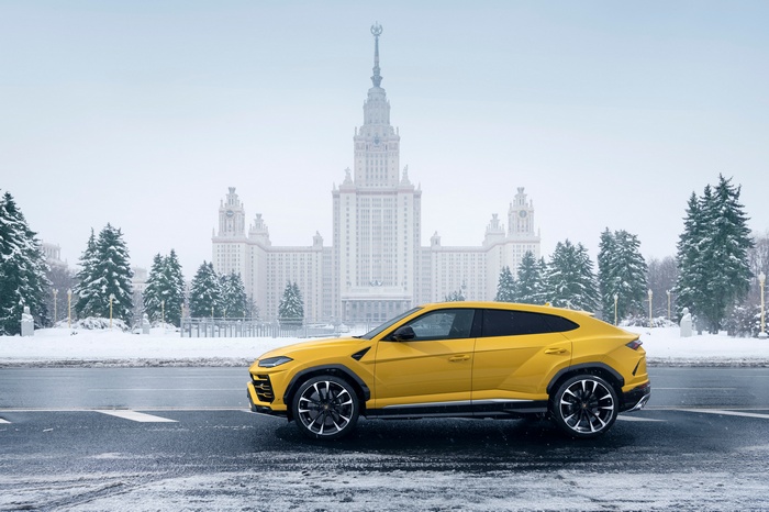 Yellow Lamborghini Urus in front of Moscow State University in winter