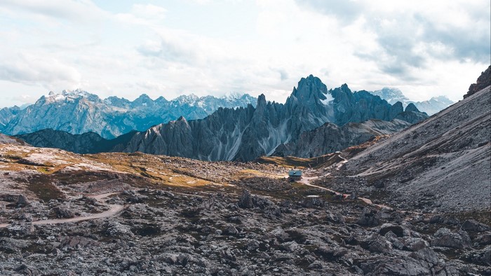 Rocky mountain range with a small cabin