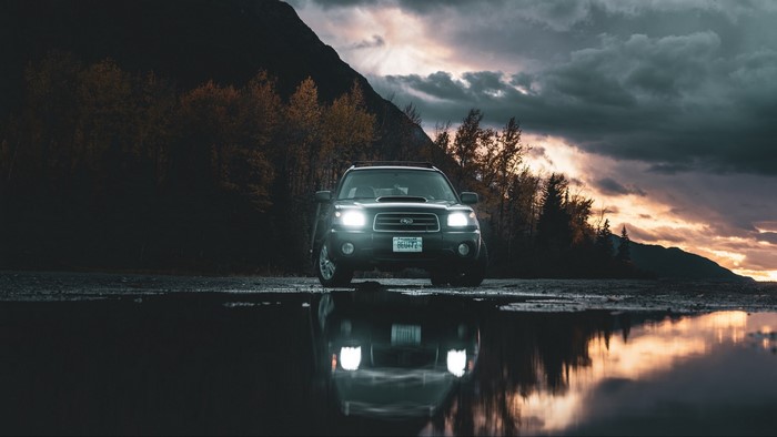 Subaru Forester SUV parked by a lake at sunset
