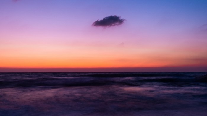 Ocean horizon at sunset with purple and orange sky