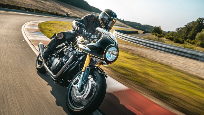 Motorcyclist on a black and gold sportbike on a race track