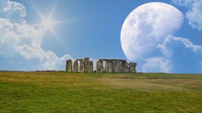 Stonehenge under a large moon and sun