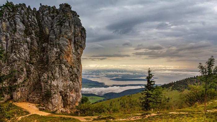 Rocky mountain peak overlooking a lake and clouds