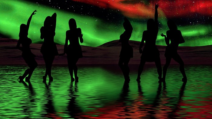 Silhouettes of dancers under the aurora borealis