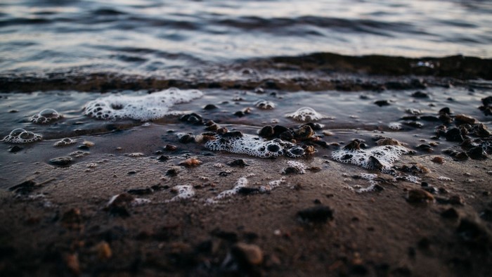 Close-up of a beach with waves and pebbles